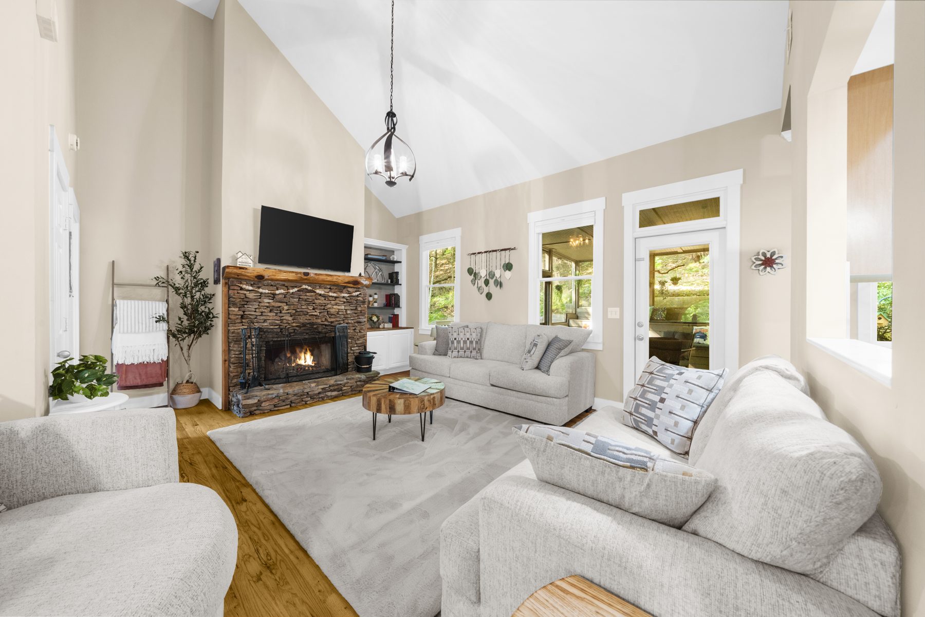 Vaulted great room with stone fireplace at Nestled Sparrow